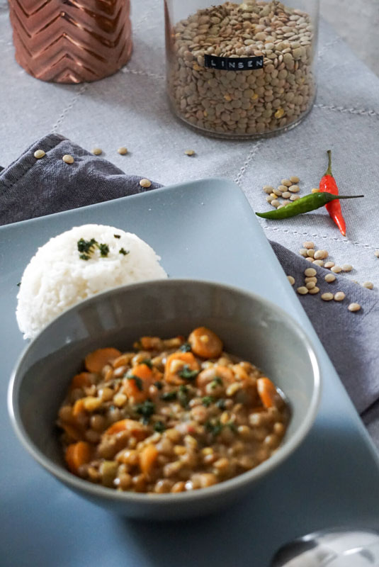 Eine Schale mit Kokos-Linsen-Curry, dazu Reis
