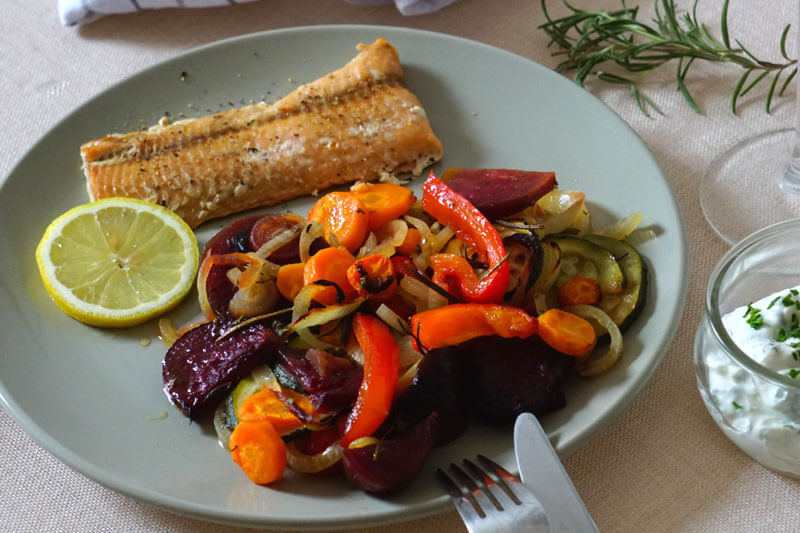 Im Ofen gebackene Rote-Beete, Parpika und Möhren auf einem Telller mit Lachs